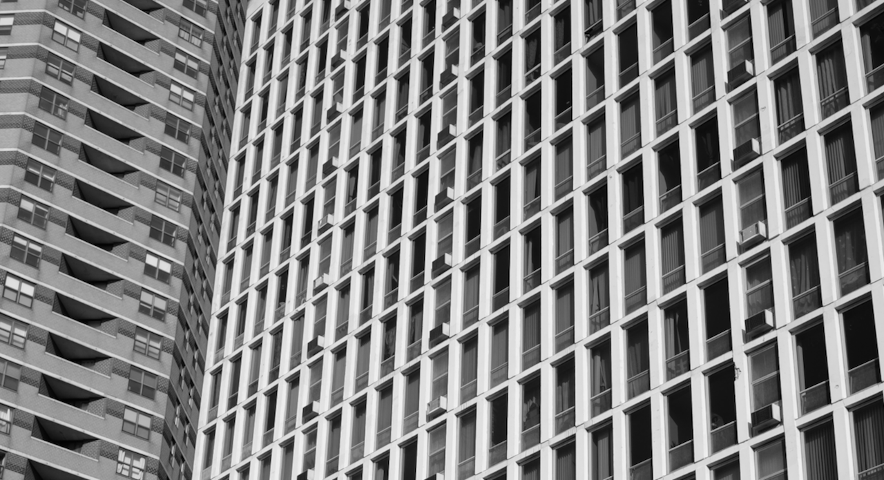Front page black-and-white hero image of two buildings intersecting visually
